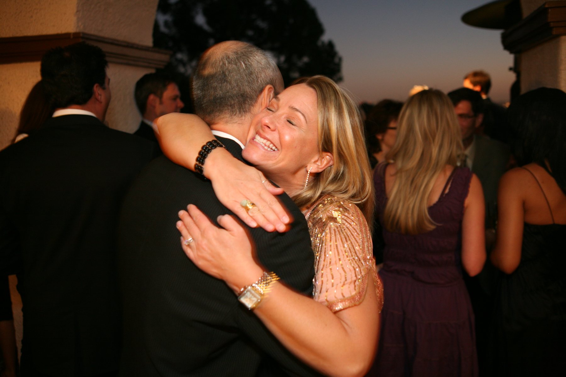 Wedding guest hugging during evening reception
